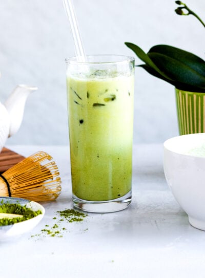 beautiful glass of green matcha latte with ice on table.
