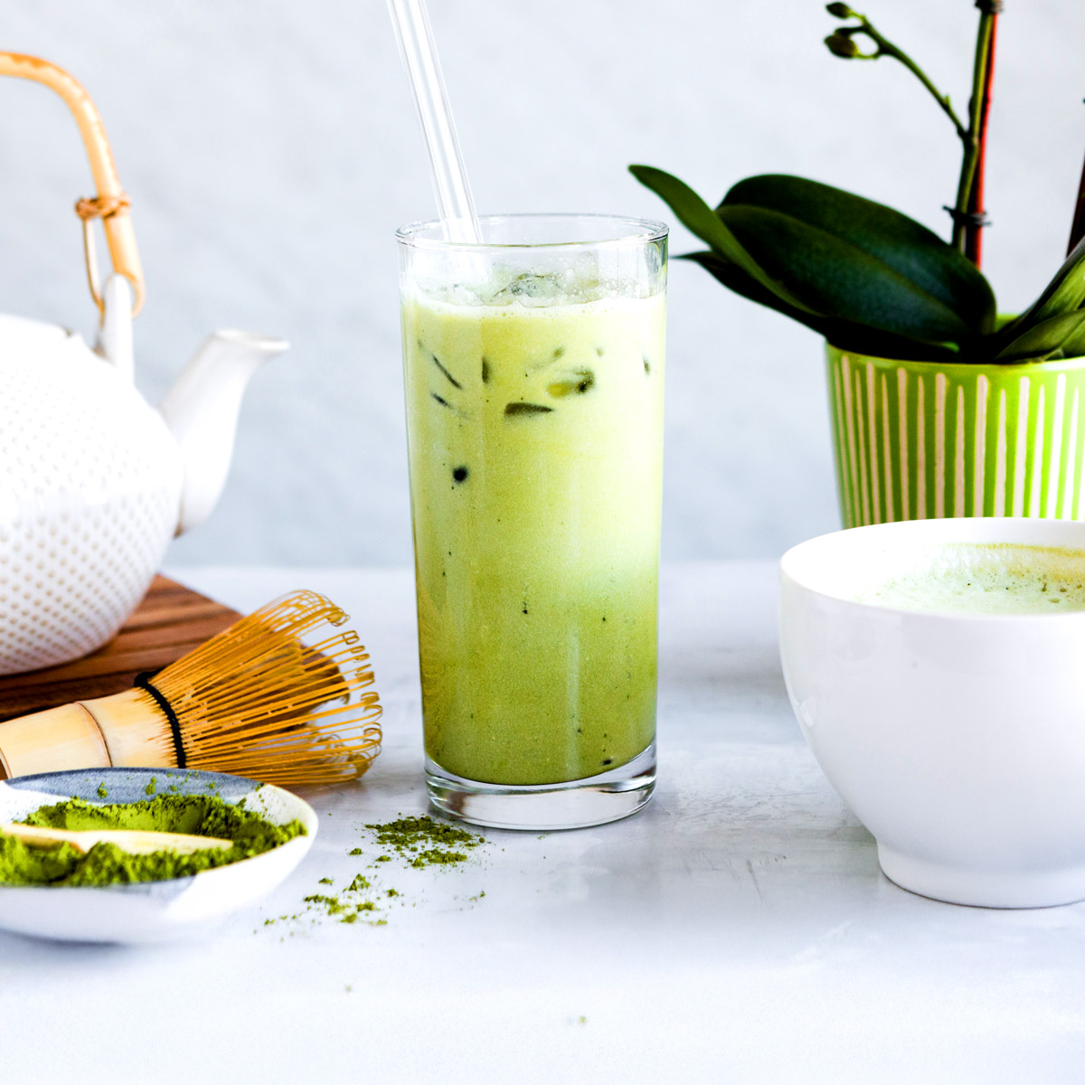 beautiful glass of green matcha latte with ice on table.