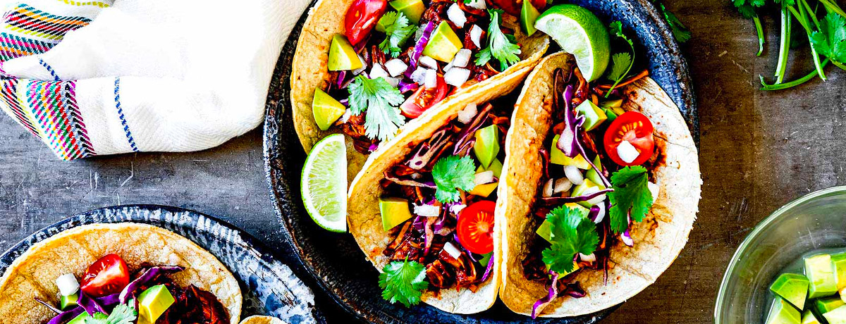 three jackfruit bbq tacos with an array of vegetables