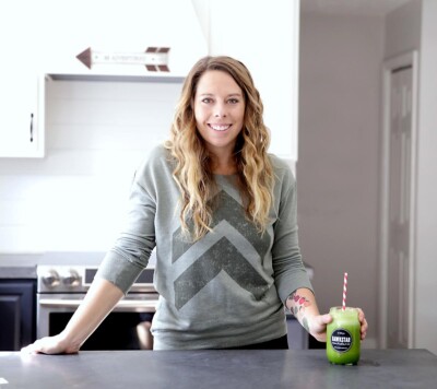 Jen Hansard in her kitchen showing how to make a smoothie.