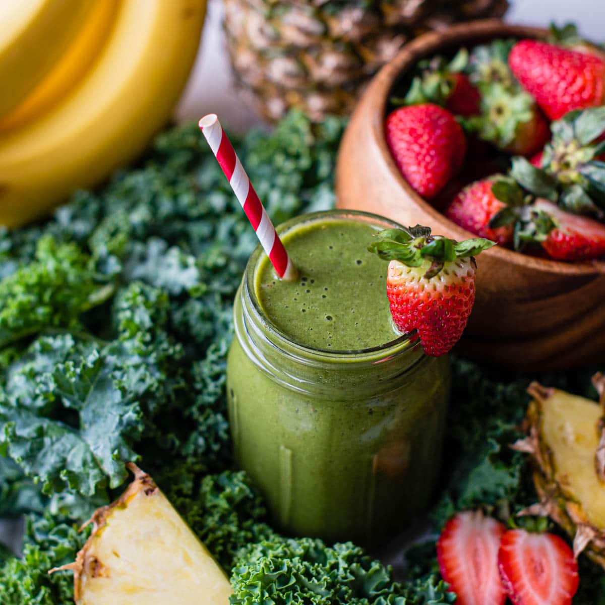 kale banana smoothie surrounded by fresh ingredients