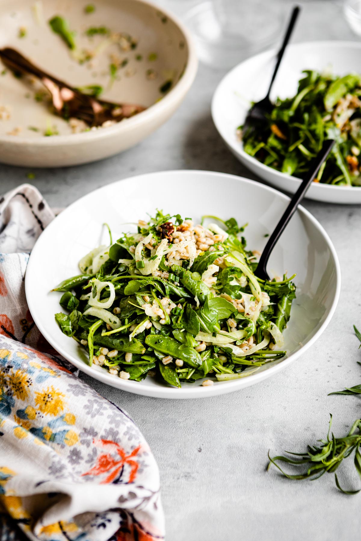 arugula salad in a white bowl with a black fork.