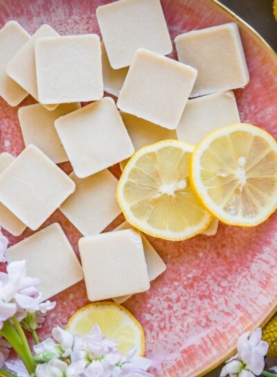 pink plate full of lemon fat bombs and fresh lemon slices.