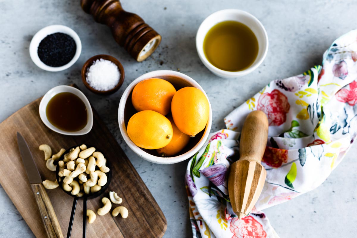 ingredients for lemon dressing including olive oil, meyer lemons, cashews, honey, sea salt and poppy seeds.