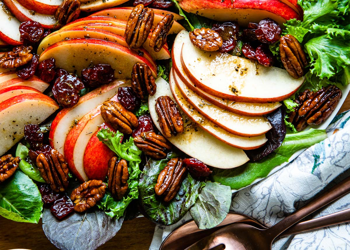 Image shows candied pecans being used as a topping for salads.