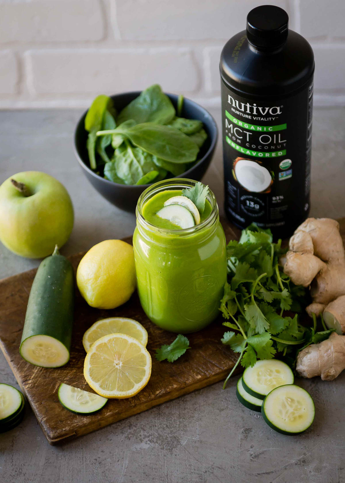 green smoothie in a glass jar with cucumber, lemon and parsley garnish.