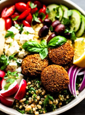 Colorful Mediterranean salad with falafel, cucumbers, tomatoes, and herbs.