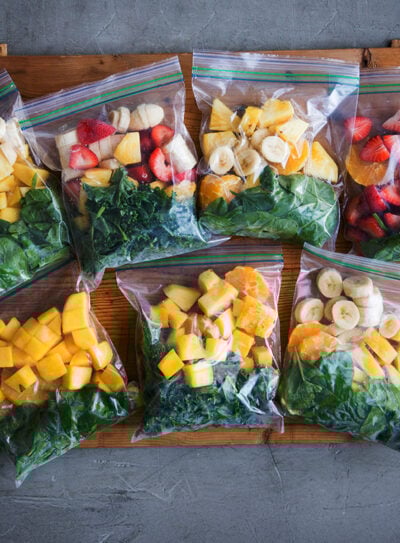 Meal prep smoothie packs for freezer on kitchen counter.