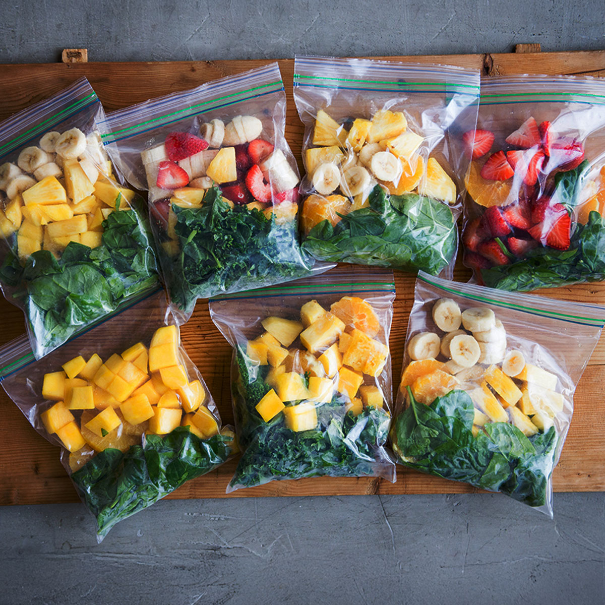 Meal prep smoothie packs for freezer on kitchen counter.