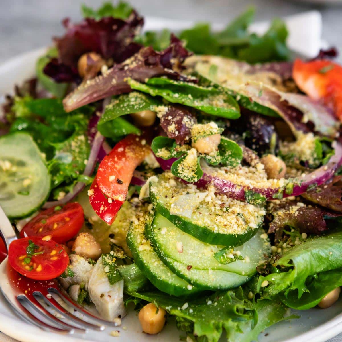 Fork on a plate with a Mediterranean Greek salad.