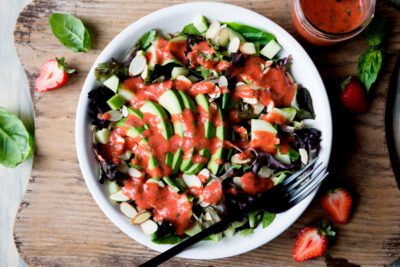 Mixed green salad with strawberry dressing.