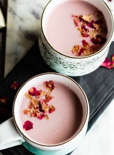 pink moon milk with culinary rose petals in 2 white mugs.