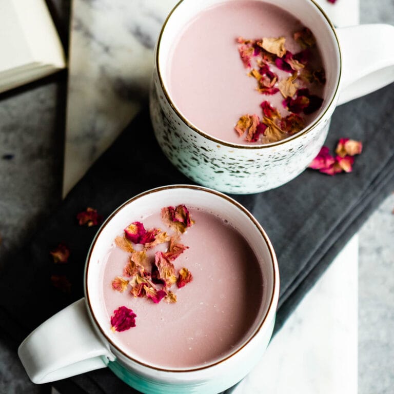 pink moon milk with culinary rose petals in 2 white mugs.