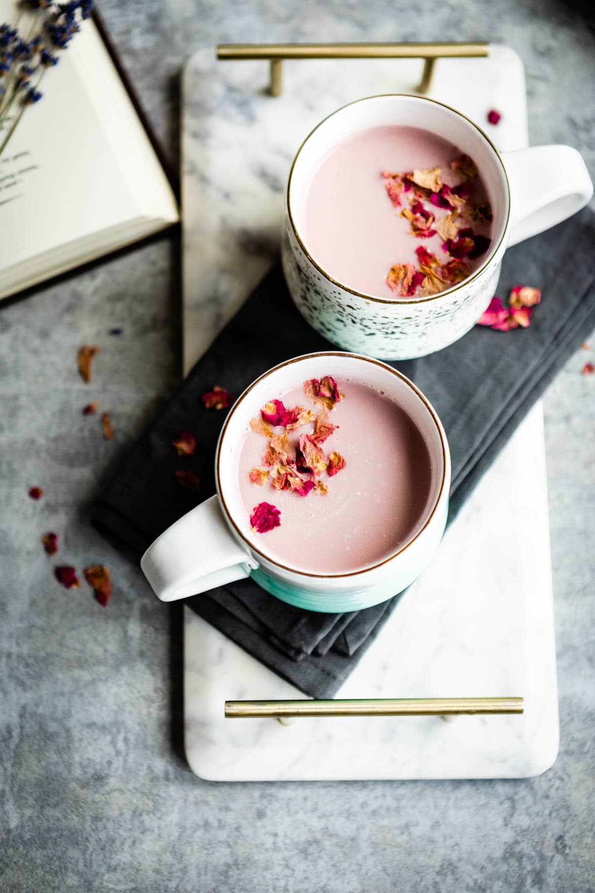 2 mugs with pink moon milk and dried rose petals.