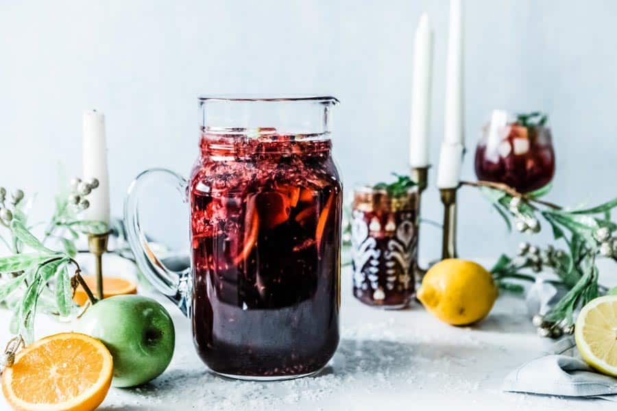 non alcoholic berry sangria in a glass pitcher on a festive table.
