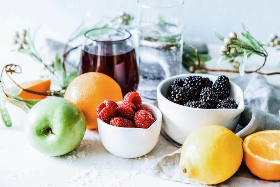 mocktail ingredients including blackberries, raspberries, orange, lemon and green apple.