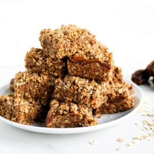 Crispy oat bars with a crumbly topping on a white plate.