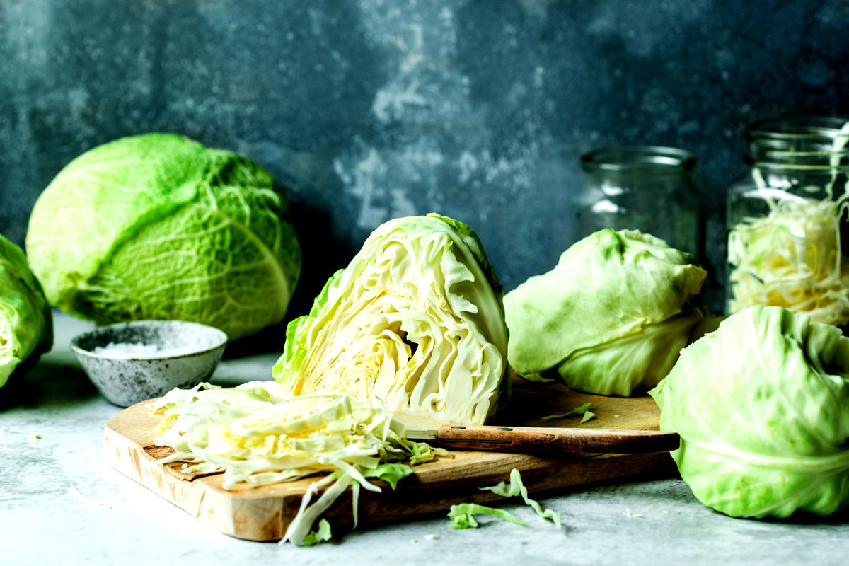 Fresh green cabbage chopped on wood board for a cabbage smoothie recipe.