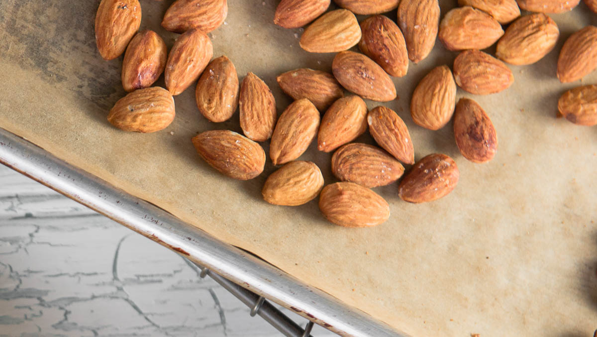 oven roasted almonds on a baking tray lined with parchment paper.