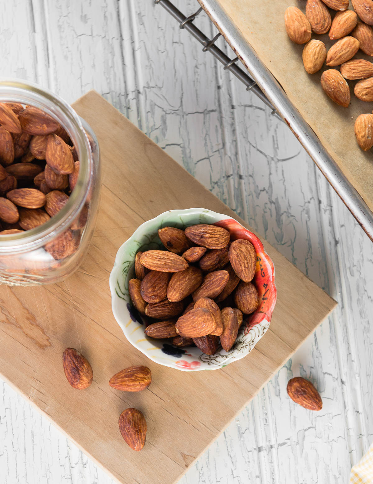 colorful snack bowl of roasted almonds recipe on a wooden cutting board.