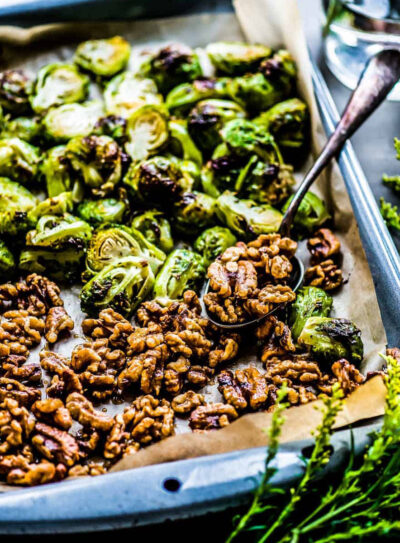 pan of oven roasted Brussels sprouts and candied walnuts on parchment paper.
