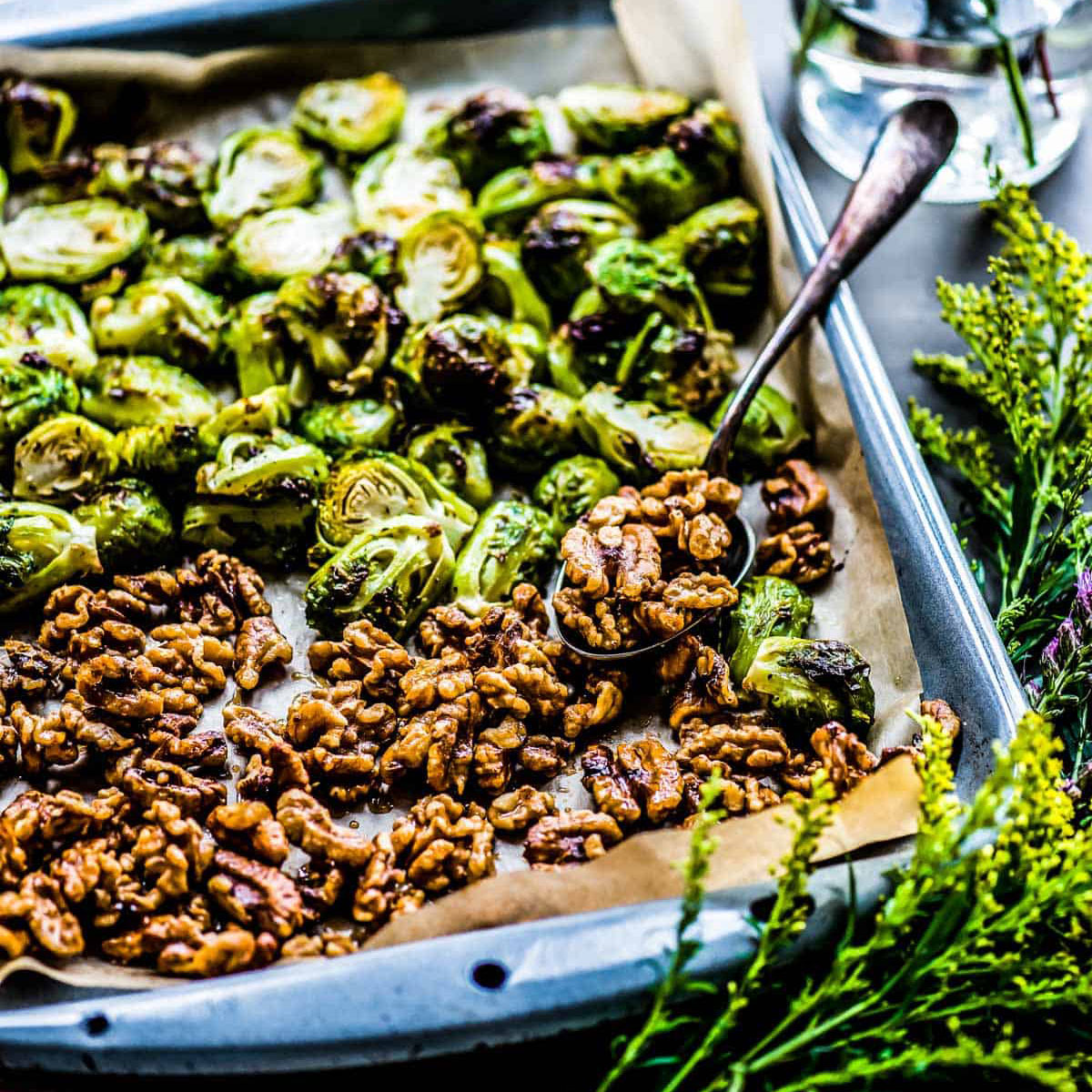 pan of oven roasted Brussels sprouts and candied walnuts on parchment paper.