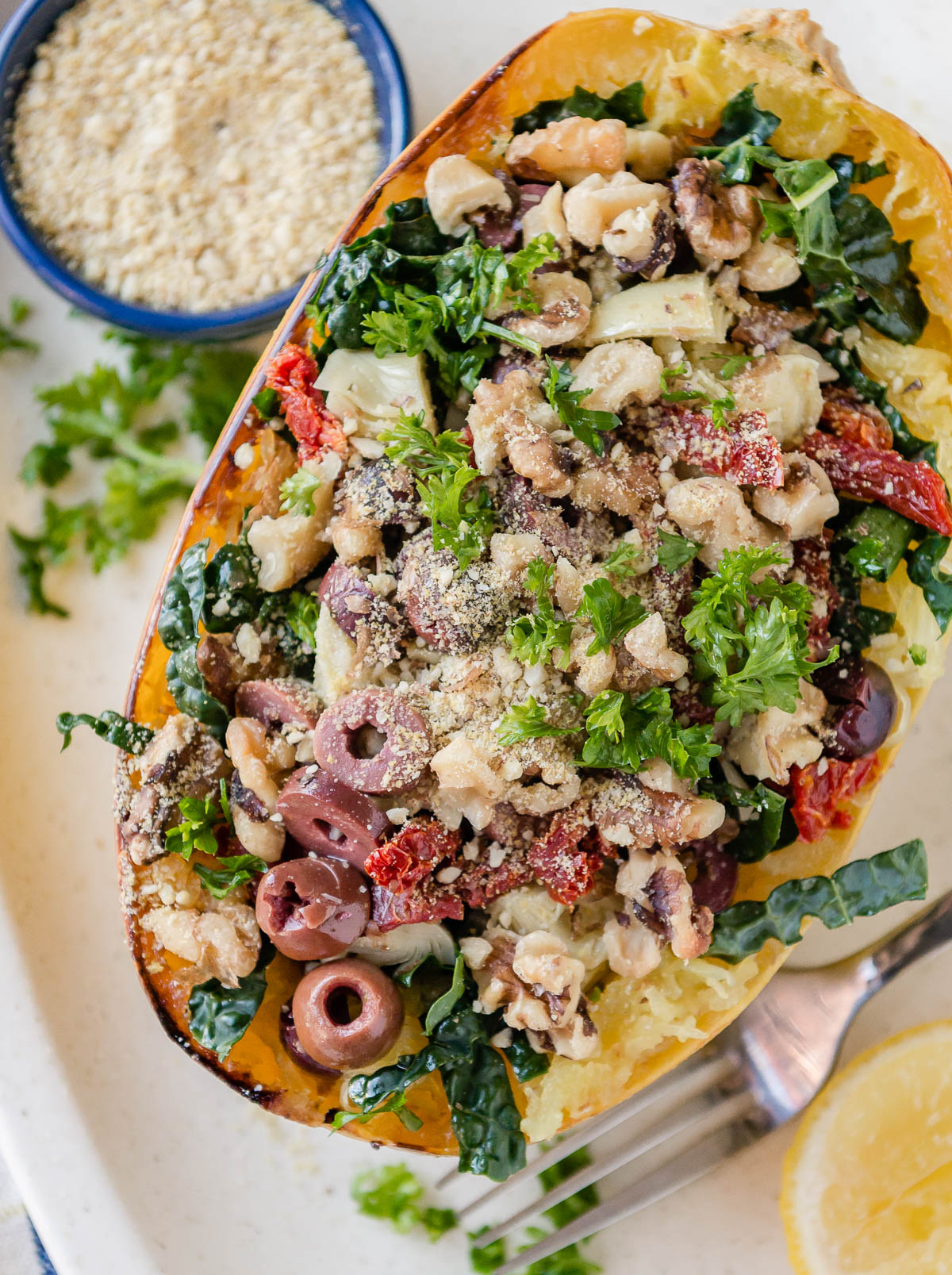half of a spaghetti squash topped with walnuts, sun-dried tomatoes, kale, artichokes and more.