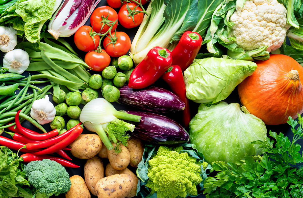 lots of Mediterranean vegetables including tomatoes, squash, peppers, bok choy, Brussels sprouts, fennel, eggplant and more all in a pile.