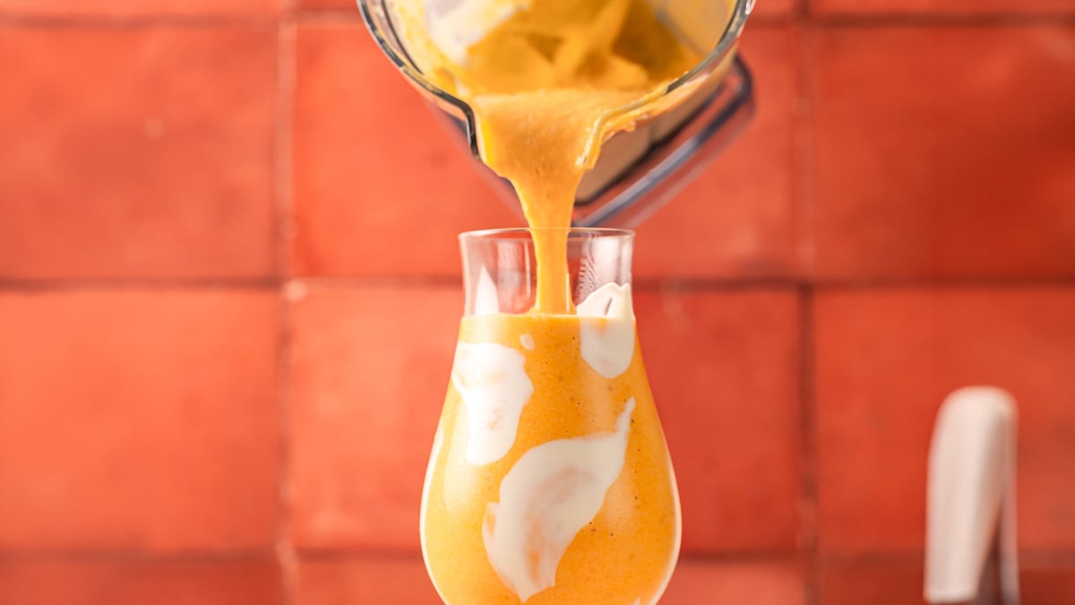 Peaches and cream smoothie surrounded by fresh ingredients