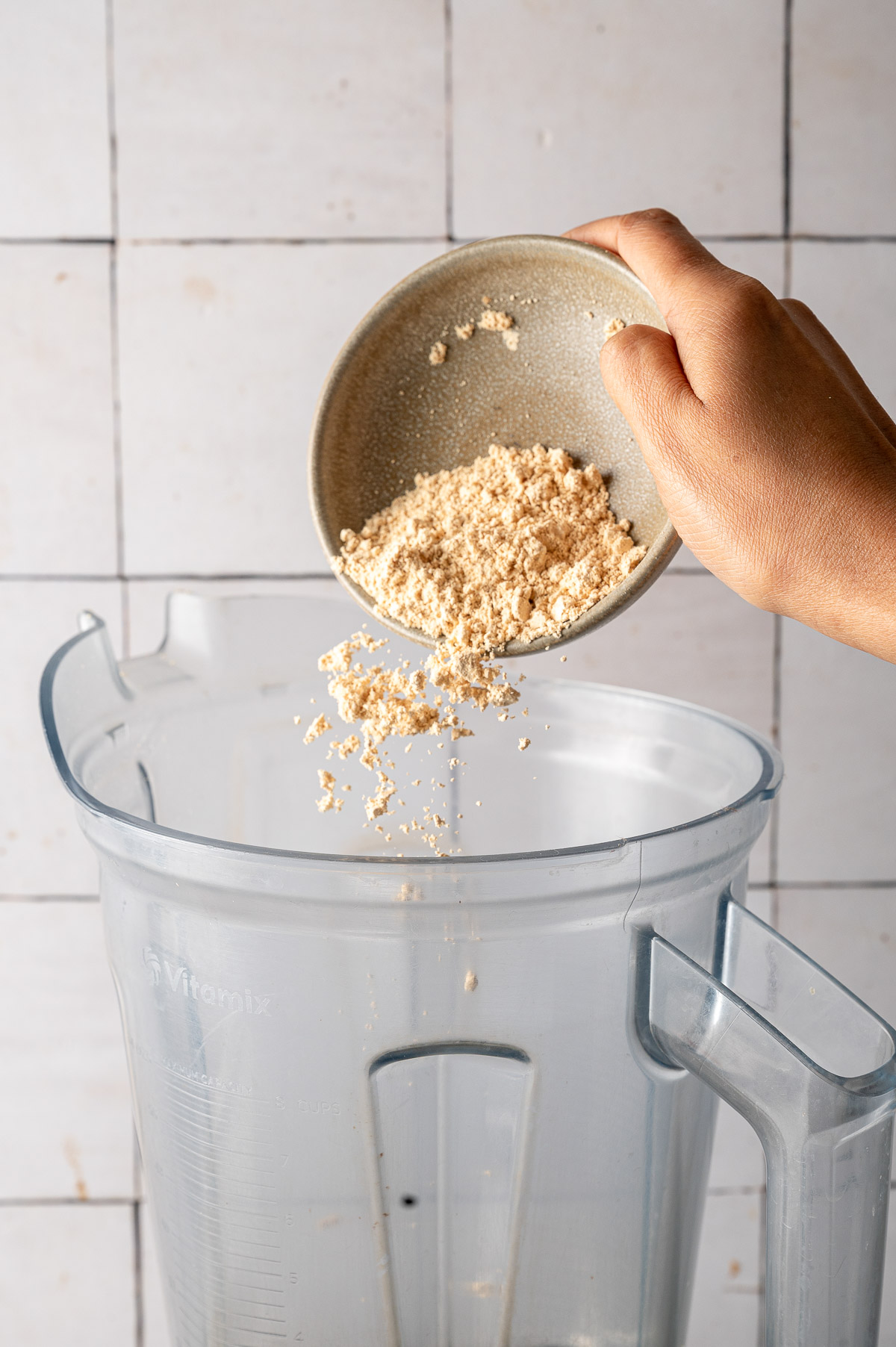 Adding protein powder and vanilla bean powder to the blender