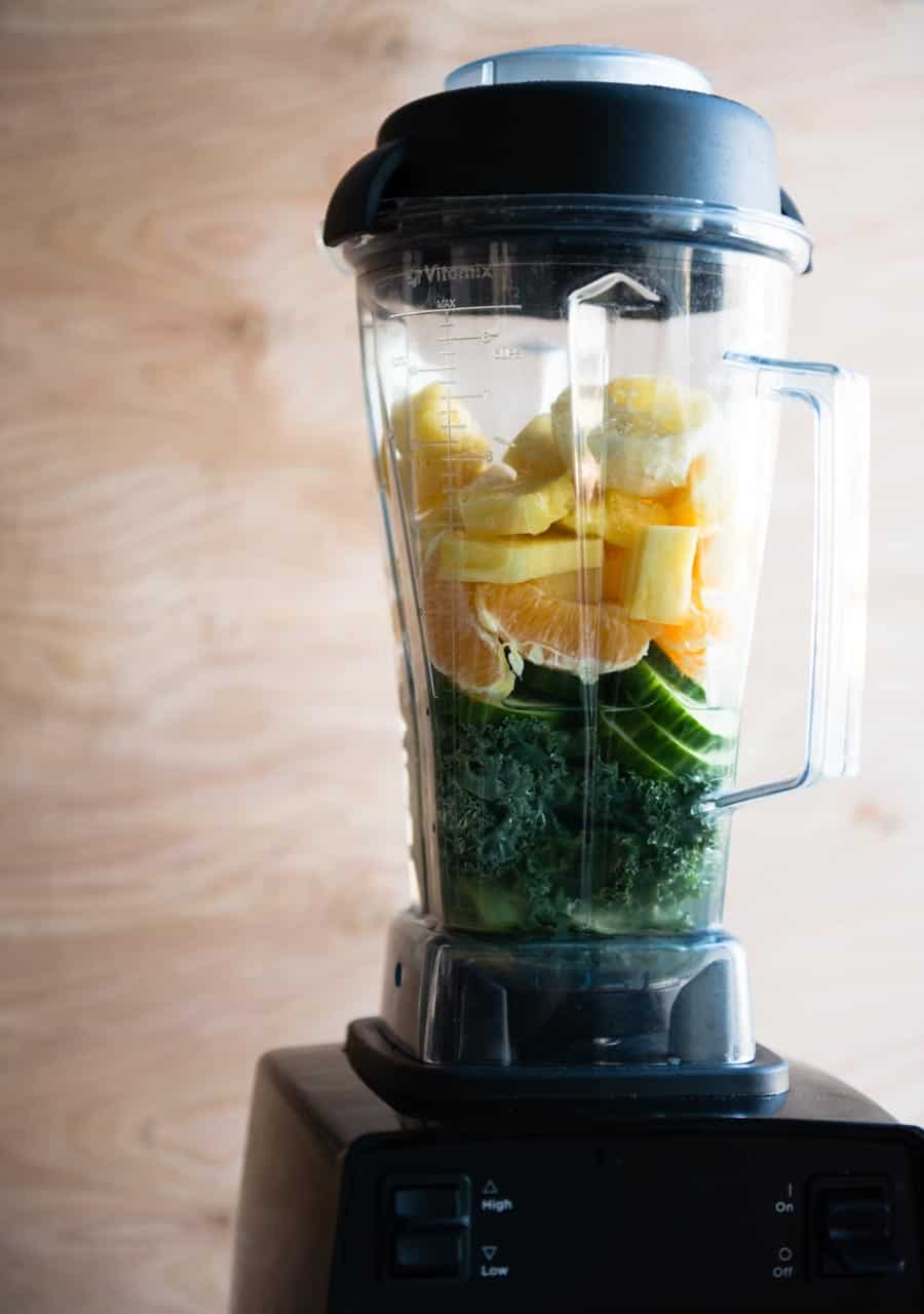 blender container full of fresh produce ingredients.