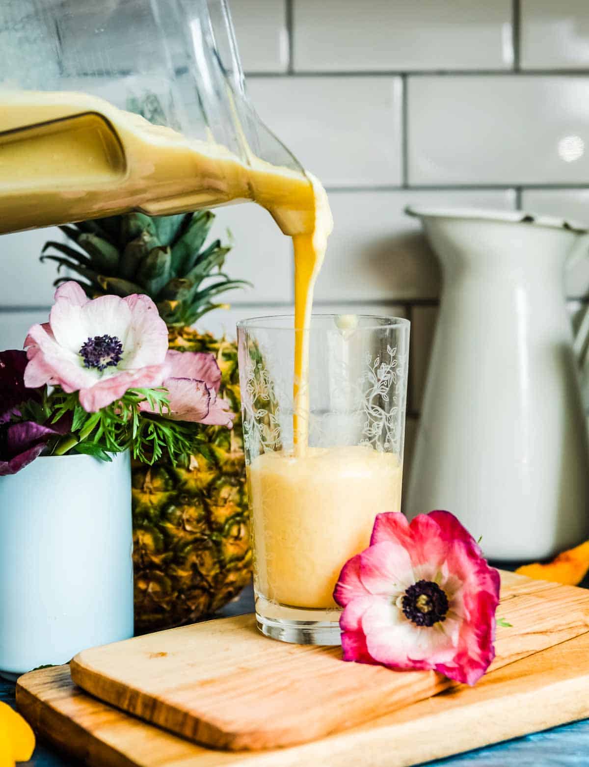 pouring a thick liquid into a glass from a blender container.