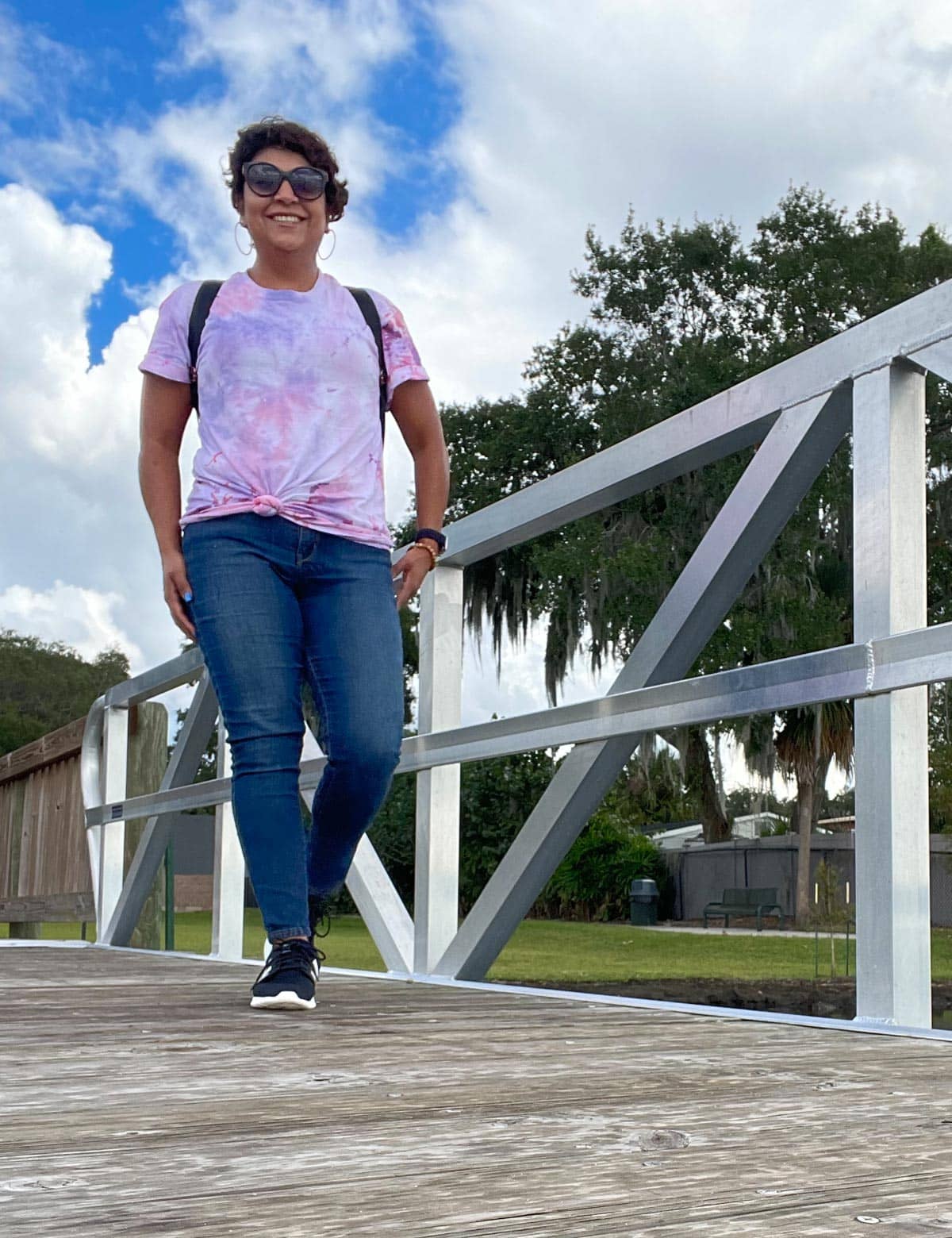 person on a bridge smiling down at the camera