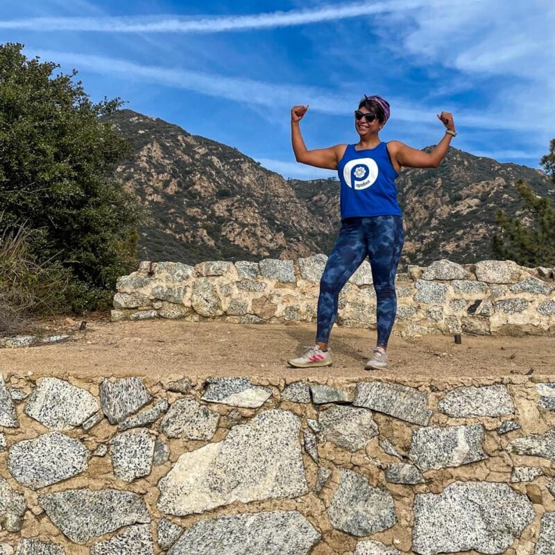 strong person on a trail with arms in the air