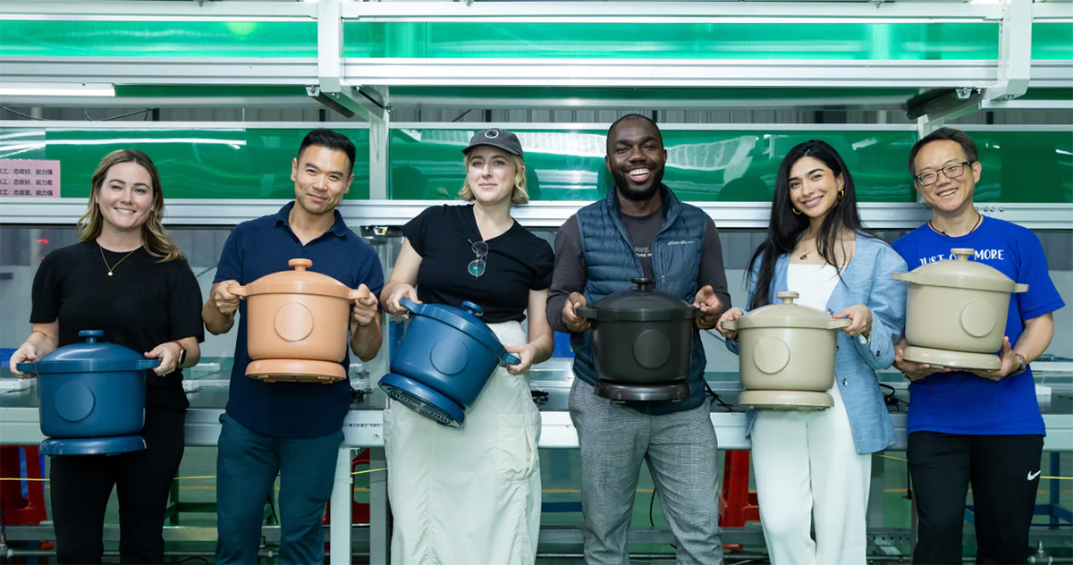 Happy friends holding crockpots side by side.