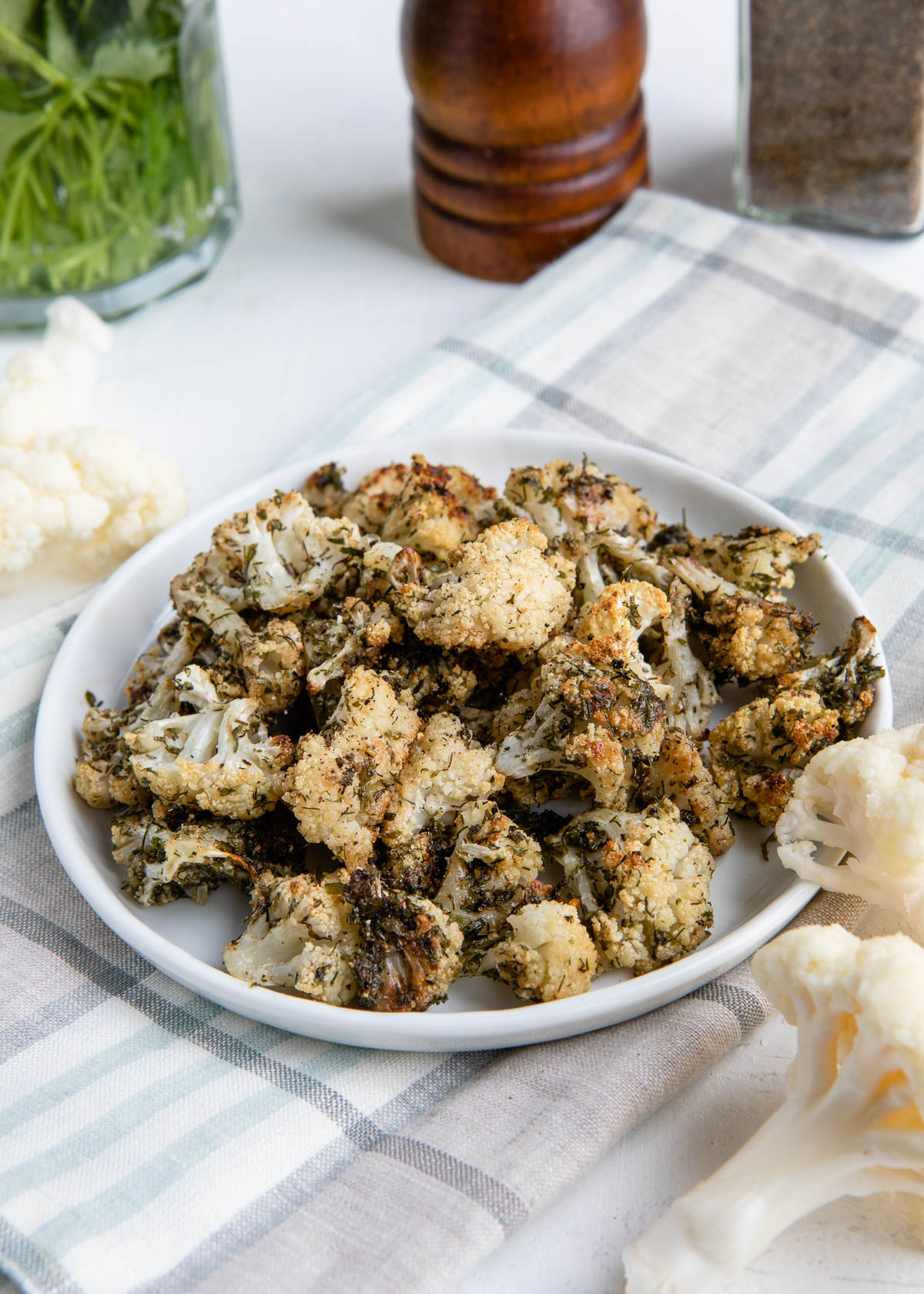 ranch cauliflower popcorn on a white 
plate on a tea towel.