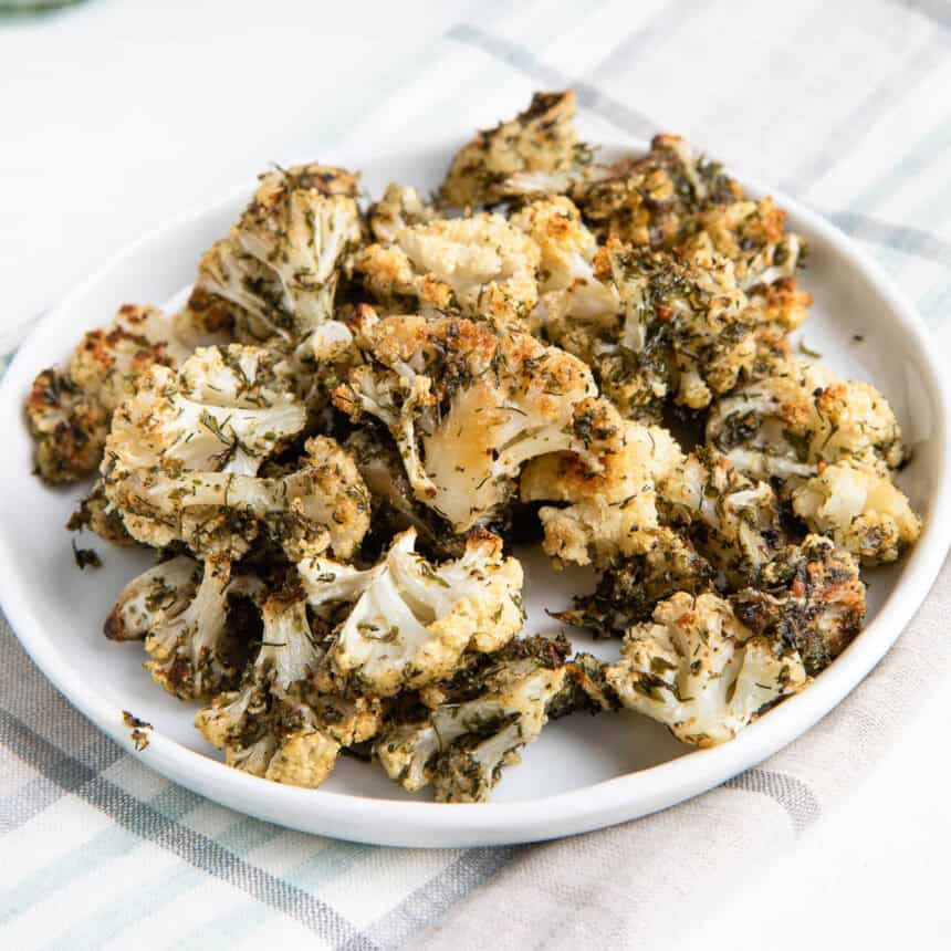 ranch cauliflower popcorn on a plate on a tea towel.