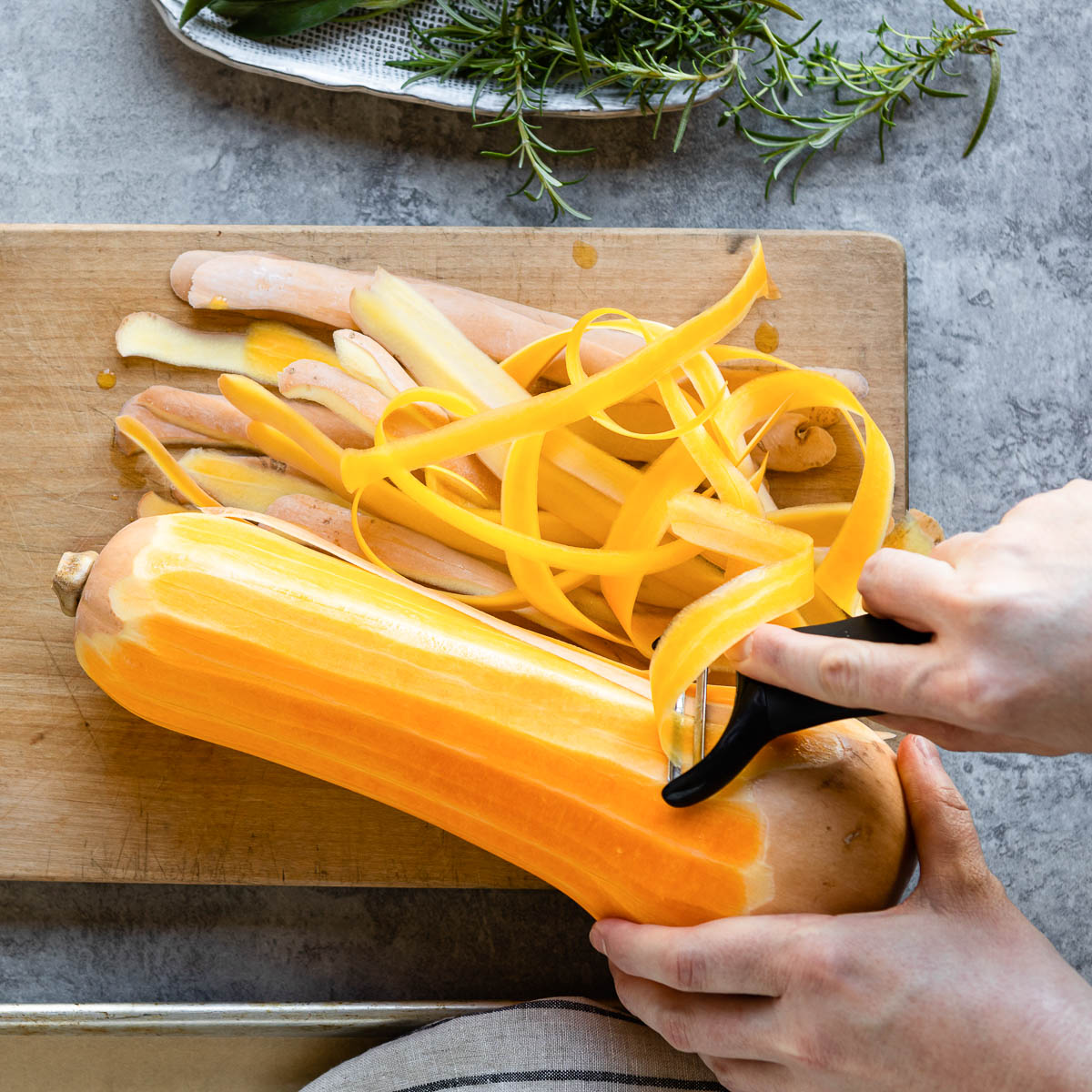 peeling a butternut squash with a sharp vegetable peeler