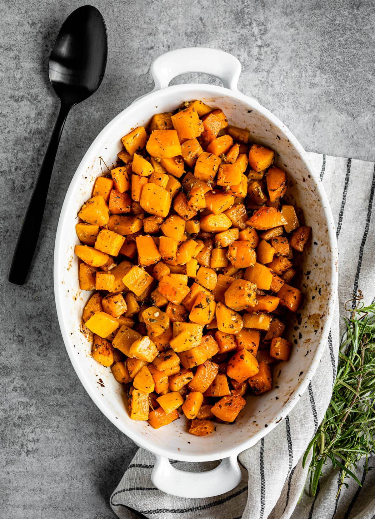 easy vegan side dish with fresh ingredients topped with herbs in a white casserole dish.