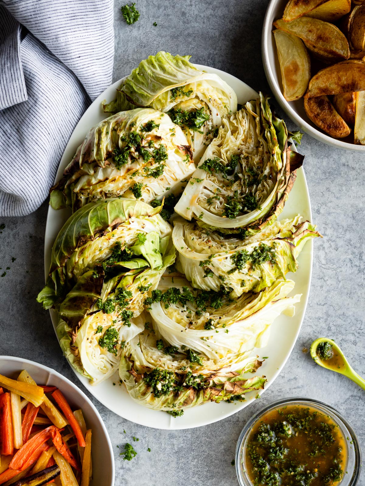 roasted cabbage with parsley seasoning and a bowl of potato wedges.