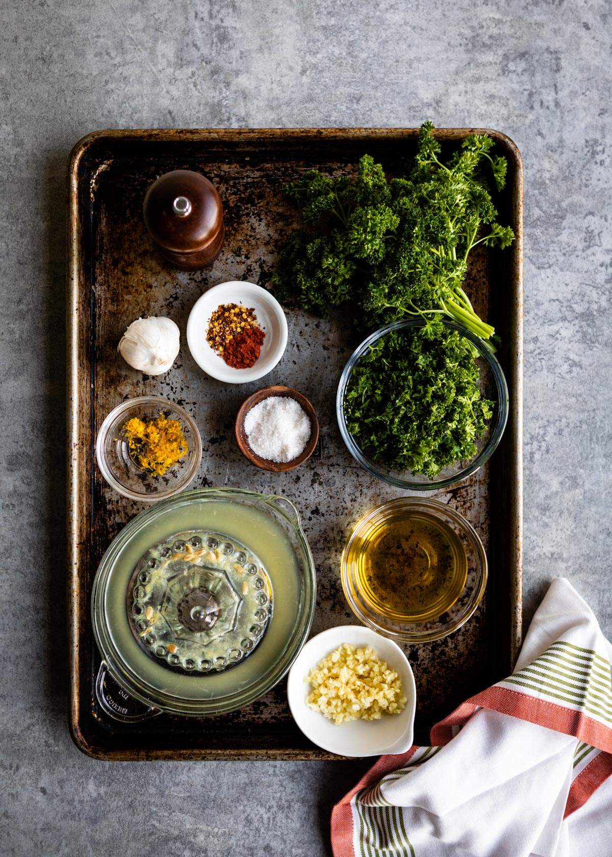 tray of seasonings for easy vegetable recipe including parsley, spices, sea salt, lemon juice, olive oil and minced garlic.