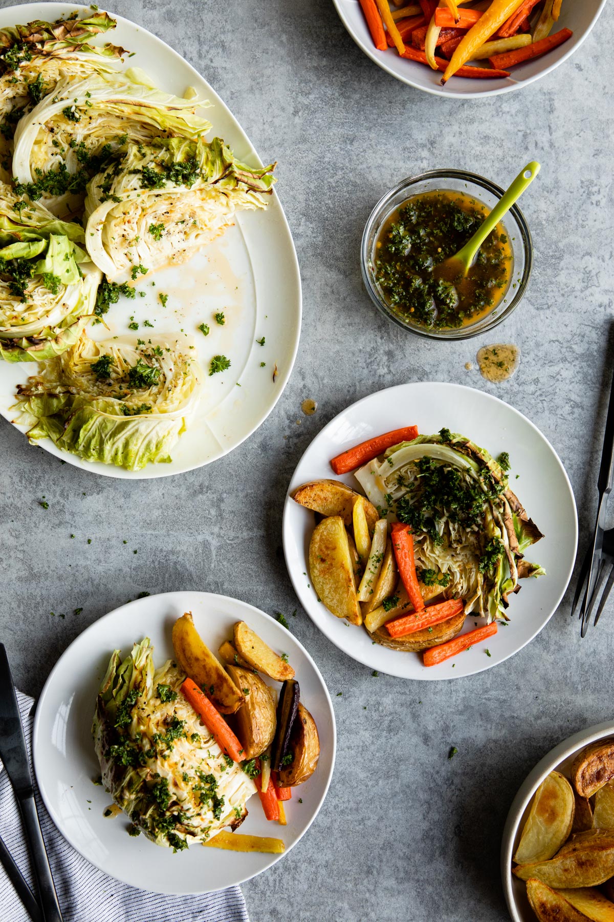 finished roasted cabbage with roasted carrots and potatoes on a table.