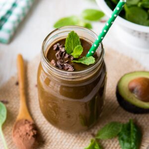 A mason jar filled with a skinny mint chocolate chip smoothie.