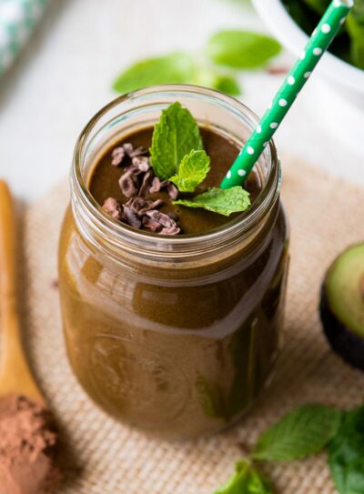 A mason jar filled with a skinny mint chocolate chip smoothie.