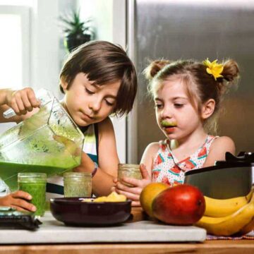 two kids pouring a green smoothie for kids
