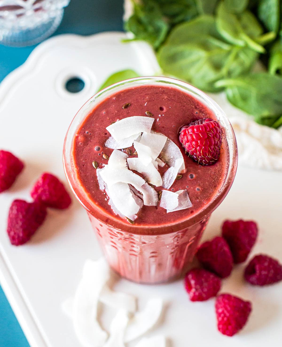 Overhead photo of smoothies for diabetics like this raspberry smoothie topped with fresh raspberries and coconut flakes.