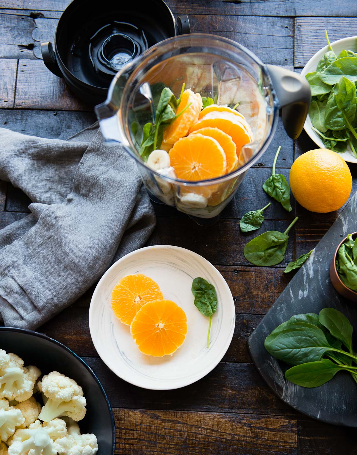 A blender container filled with ingredients for making spinach banana smoothie.