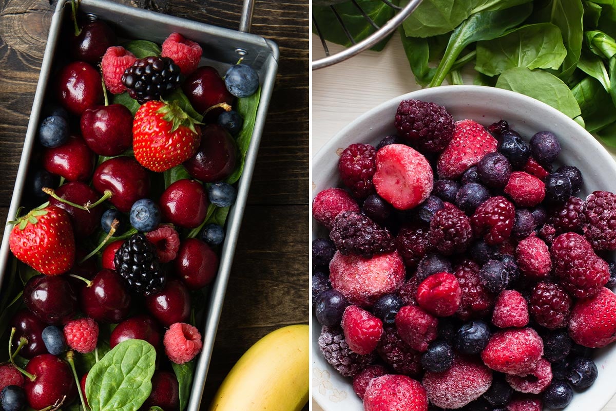 Fresh blackberries, strawberries and blueberries in a metal container on wood table next to a white bowl of frozen berries and spinach.