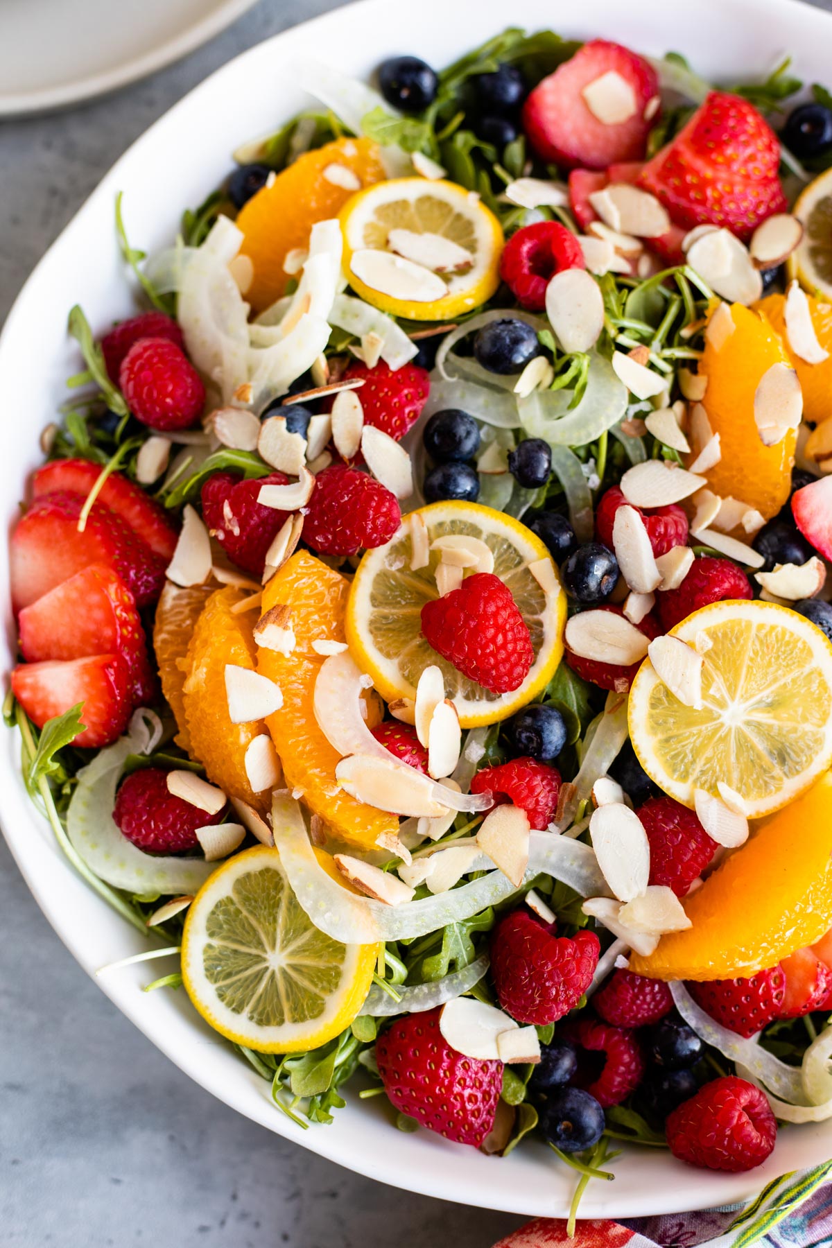 fruit and fennel salad with raspberries, strawberries, lemon, oranges and sliced almonds.