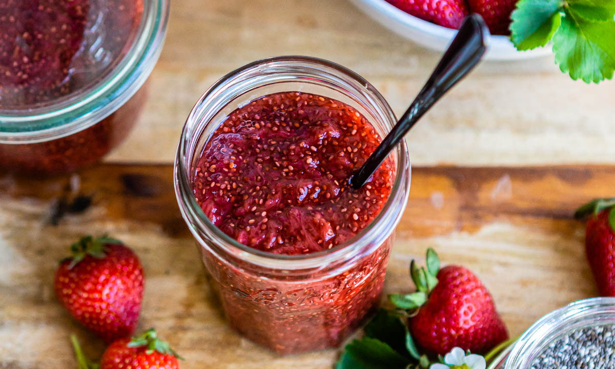 homemade jam in a jelly jar with a spoon.